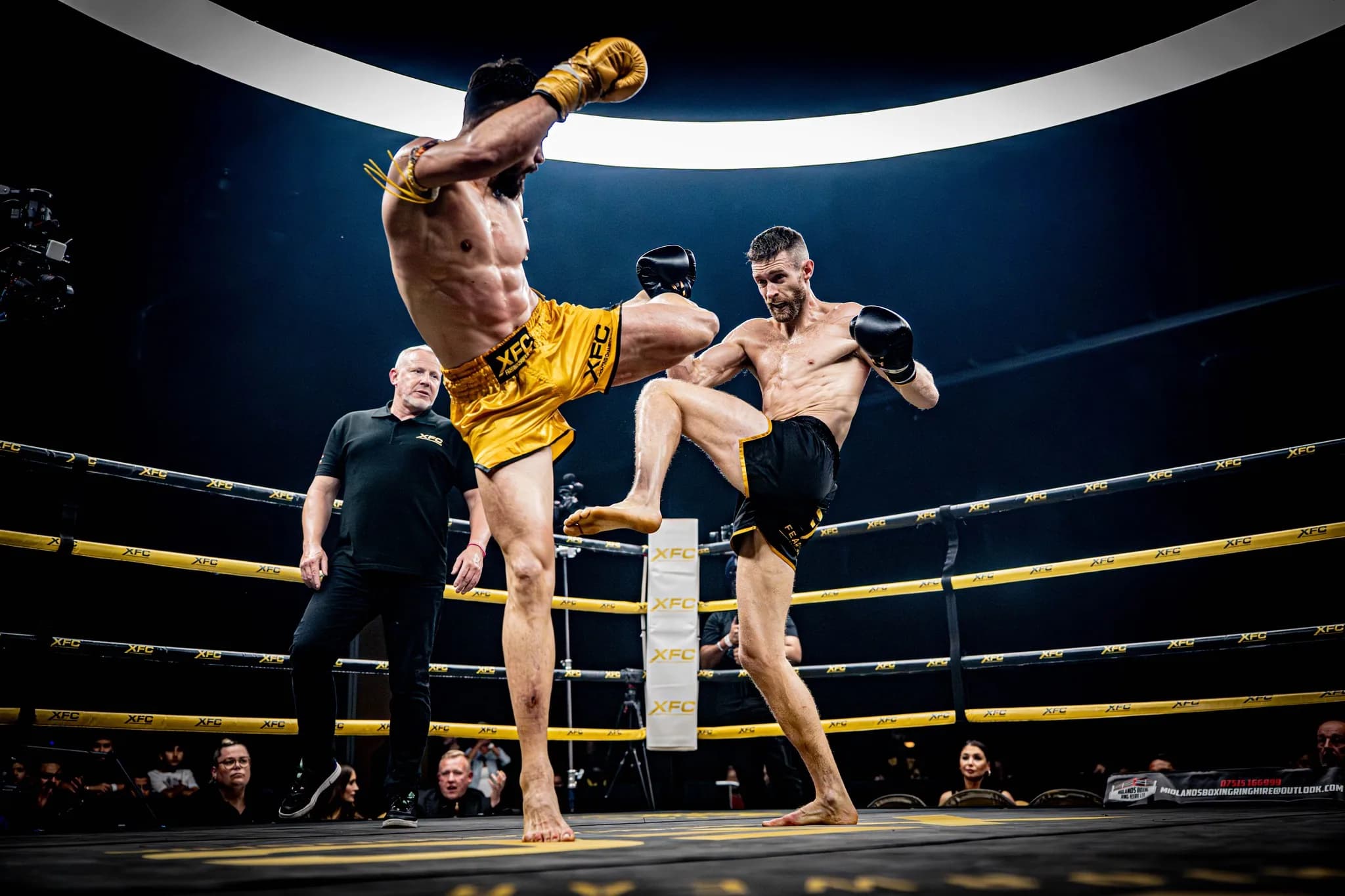 Two XFC fighters trading and checking kicks in the centre of the ring.